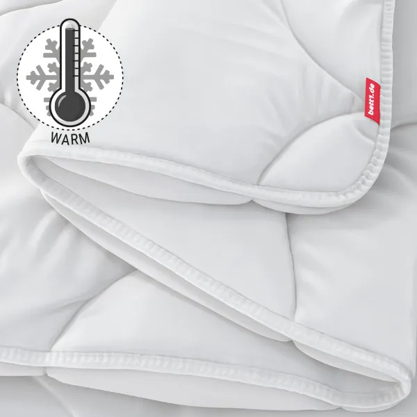 Die zusammengefaltete BODYGUARD Winterdecke warm. Illustration eines Thermometers, das eine hohe Temperatur zeigt. Text: warm